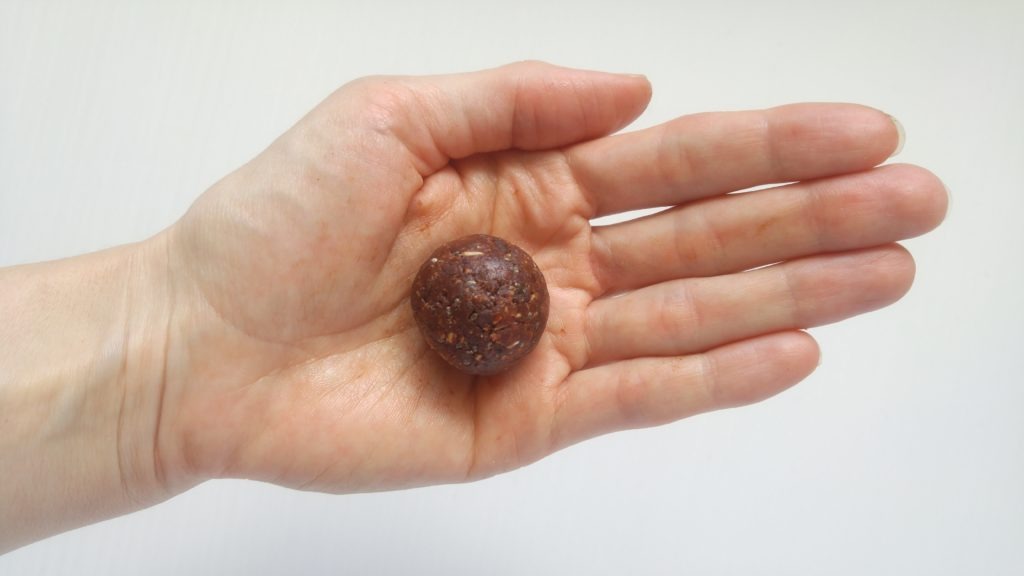 a hand holding a round energy ball 