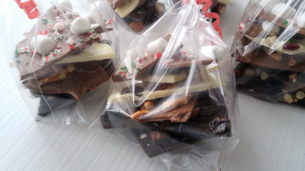 Chocolate bark packaged in small, clear, celophane bags, tied with red ribbon.