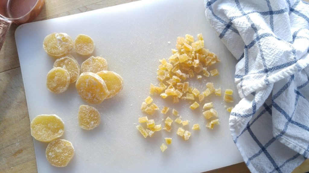 Sliced and chopped chrystalized ginger on a cutting board.