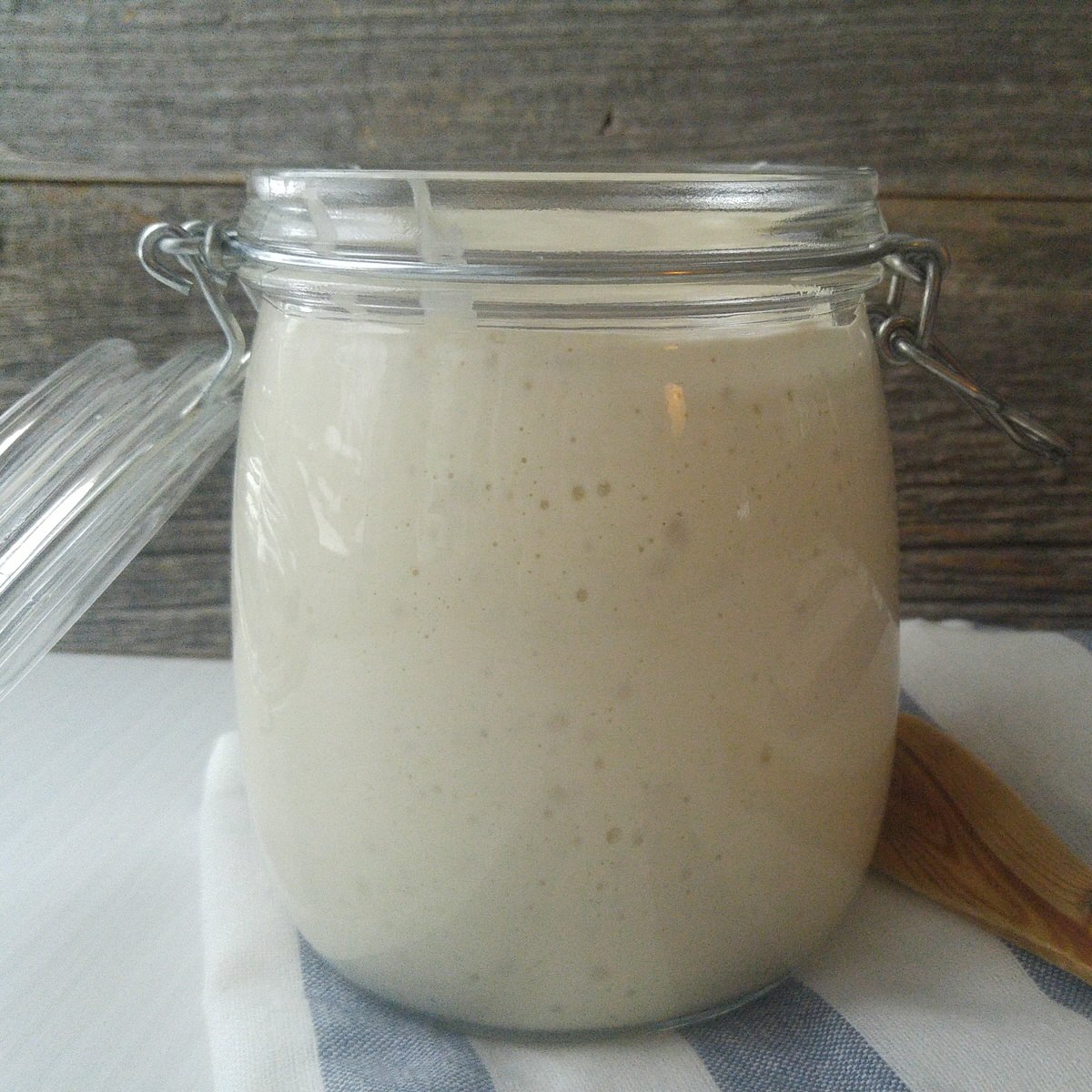 clear jar full of bubly sourdough starter