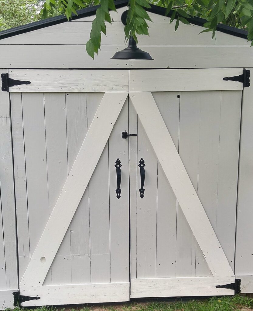 close up of black door handles and hinges on a shed door