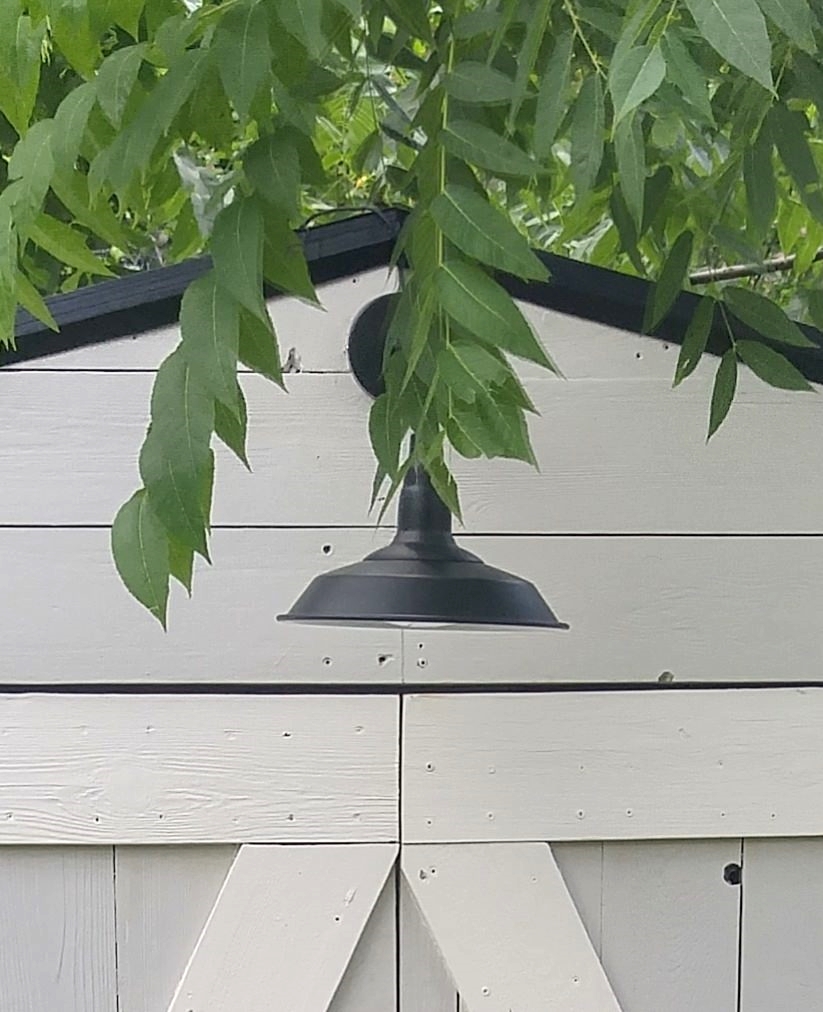 close up of black barn light above grey shed door