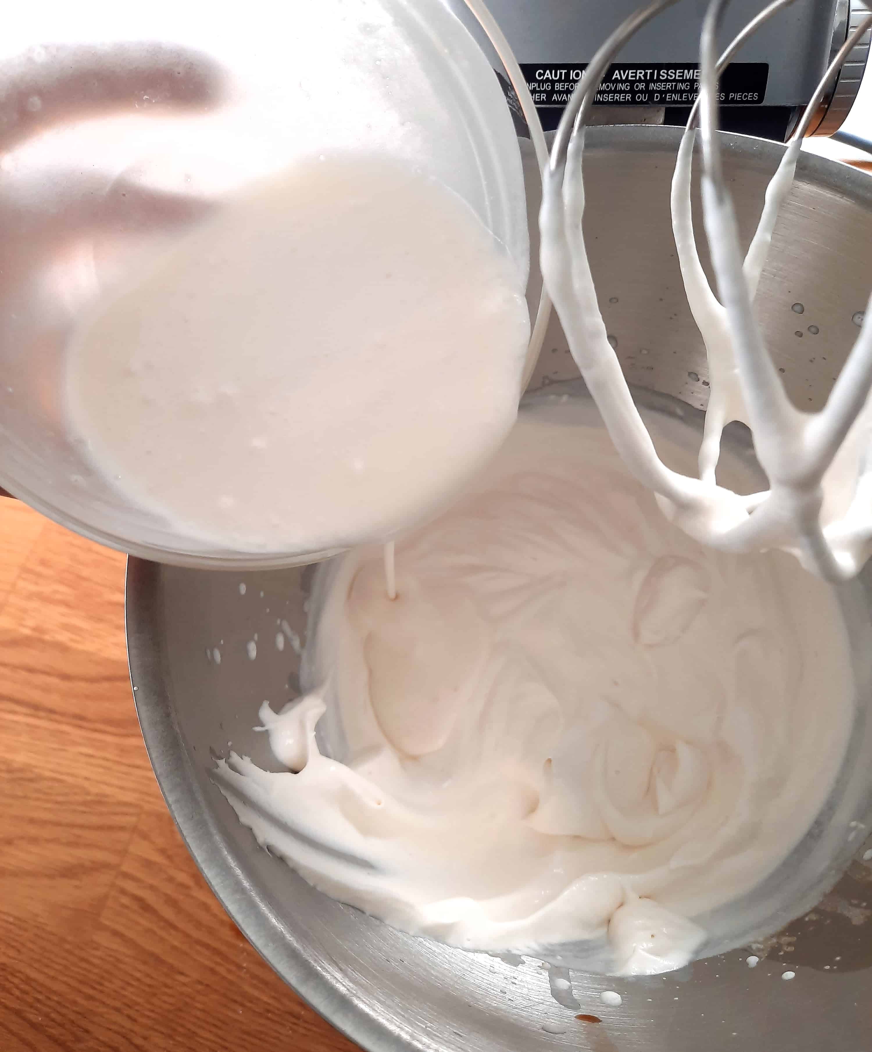 white liquid is being poured into whipped cream