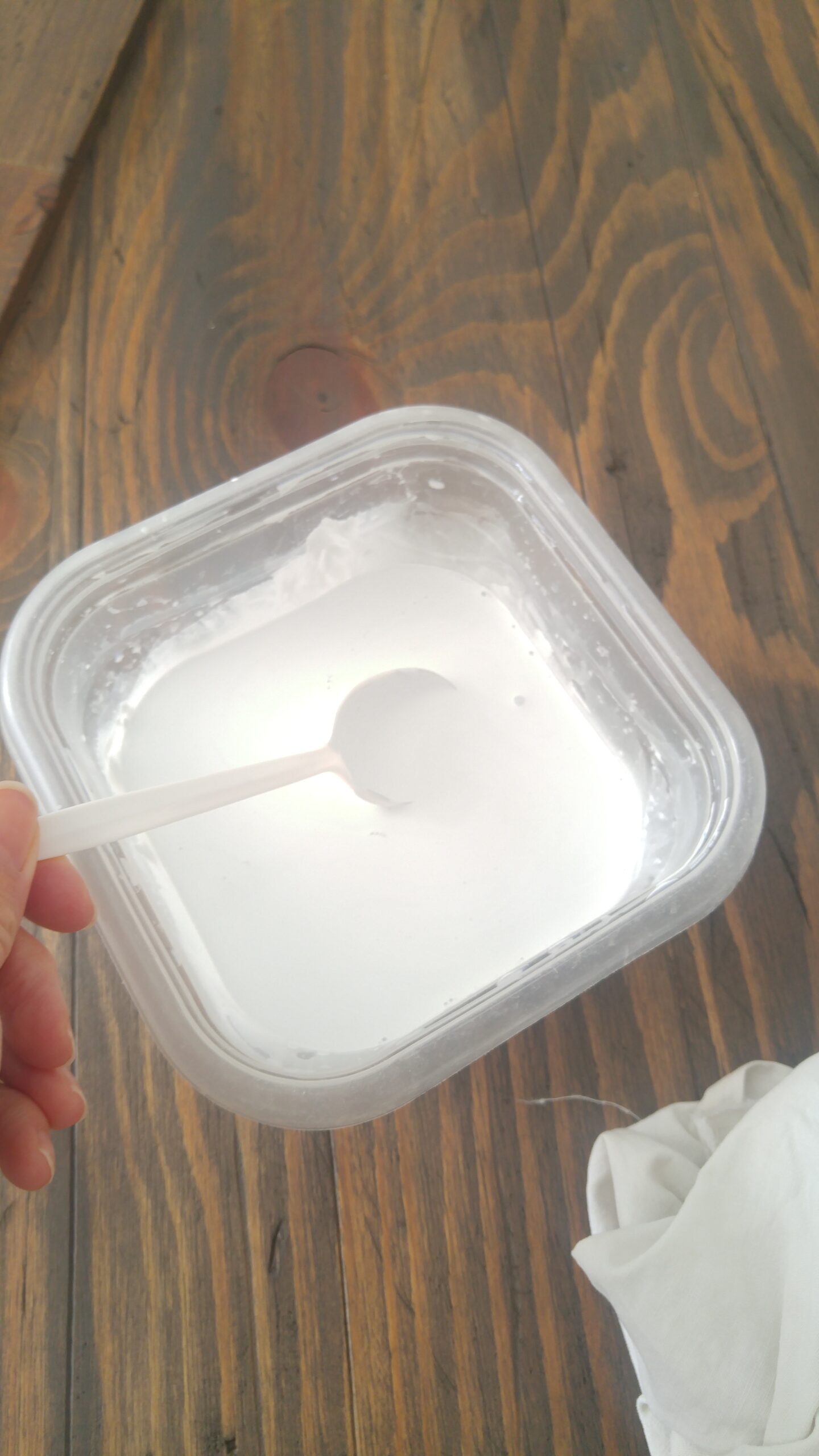 white paint mixed with water in a plastic container