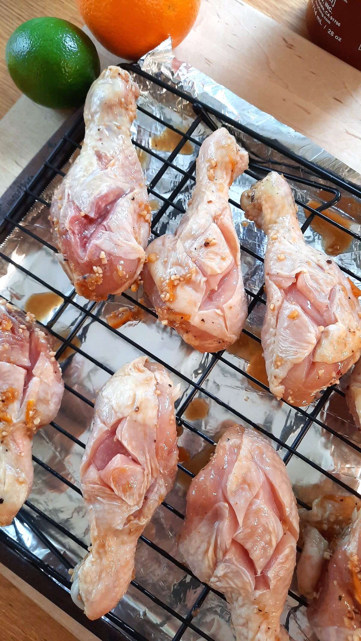 raw chicken drumsticks with knife scoring on them