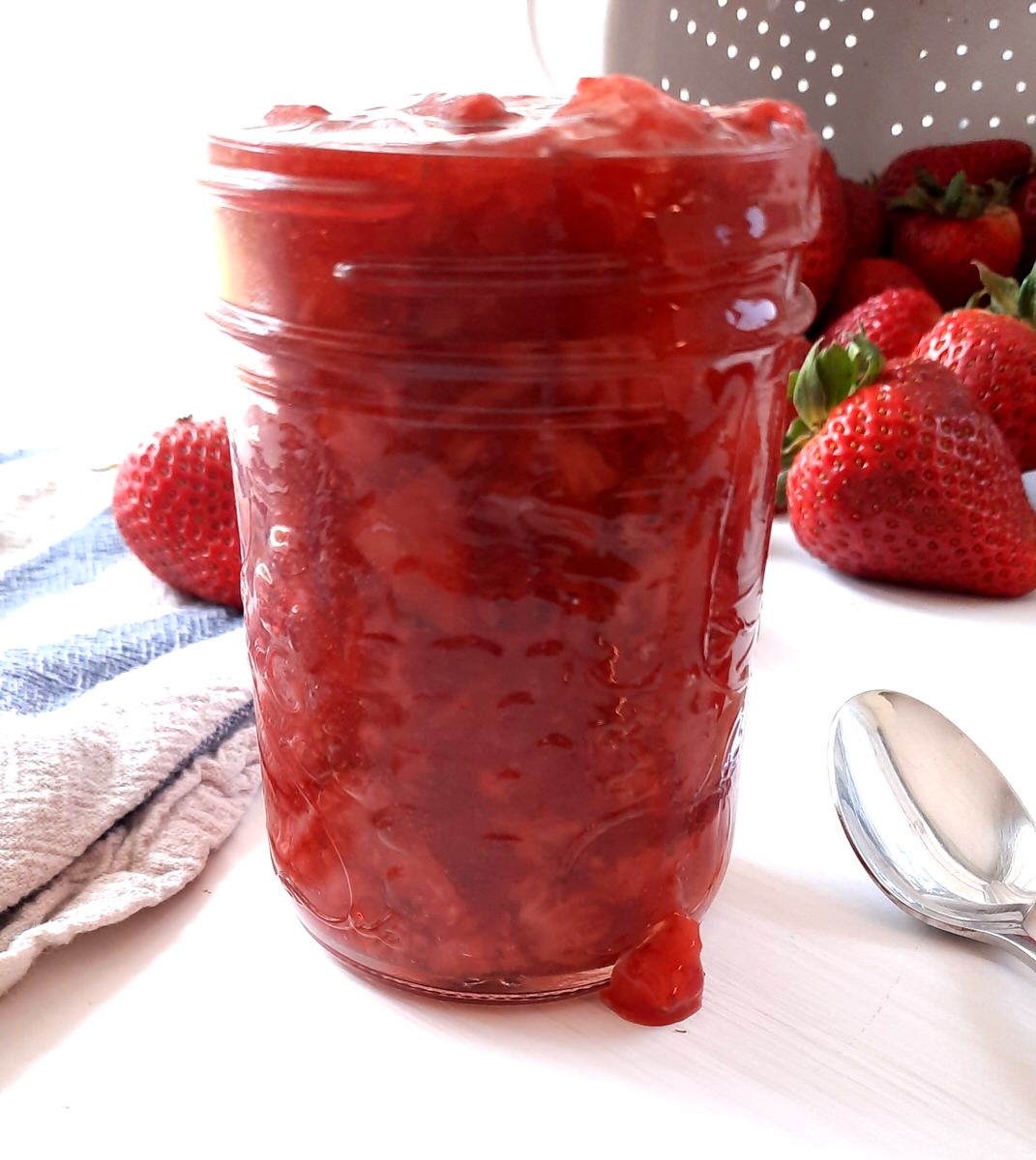 close up of a mason jar of simple strawberry sauce