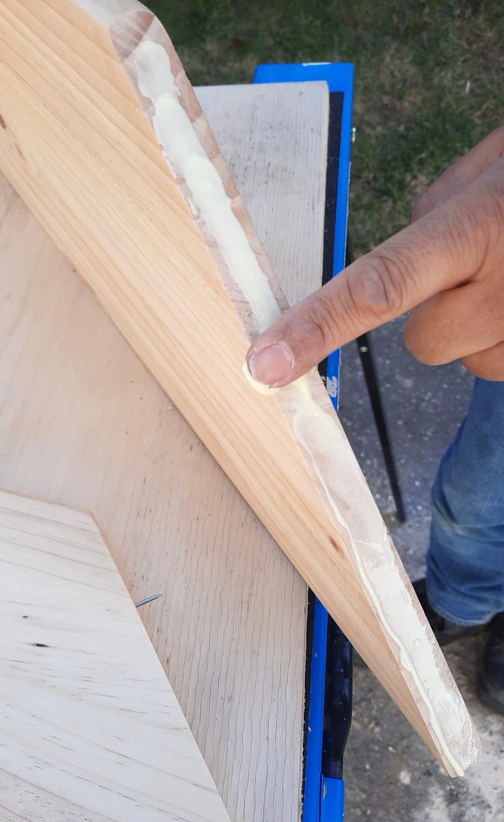 spreading glue with a finger on the cut edge of a board