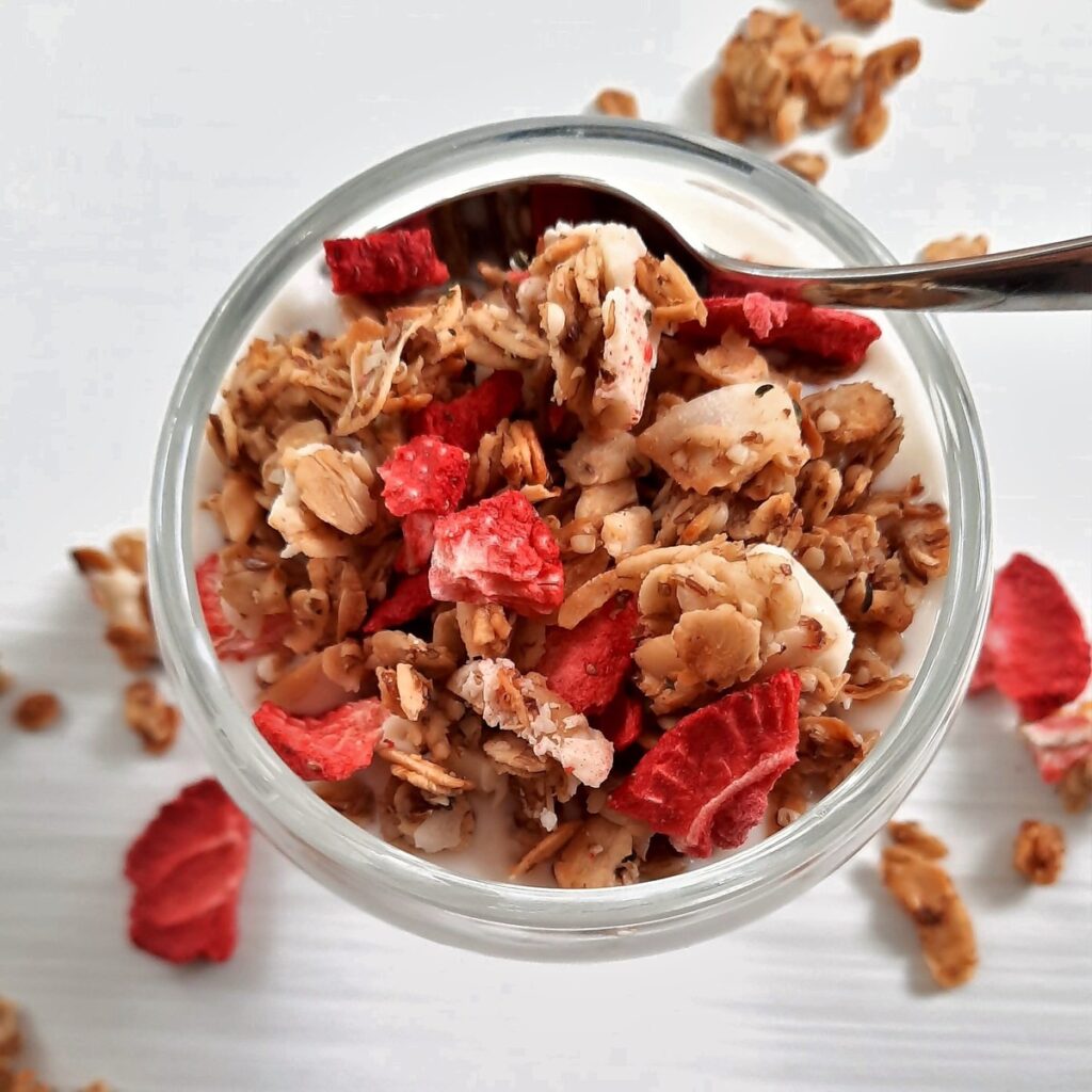 a bowl full of strawberry granola and yogurt with a spoon in it
