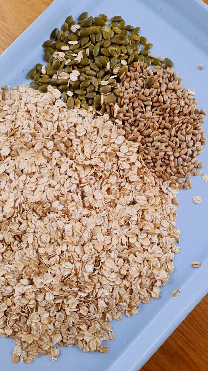 oats, pumpkin seeds, sunflower seeds on a baking sheet