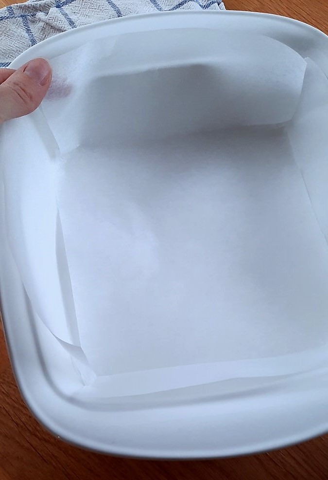 white parchment paper lining a white 9 inch baking dish