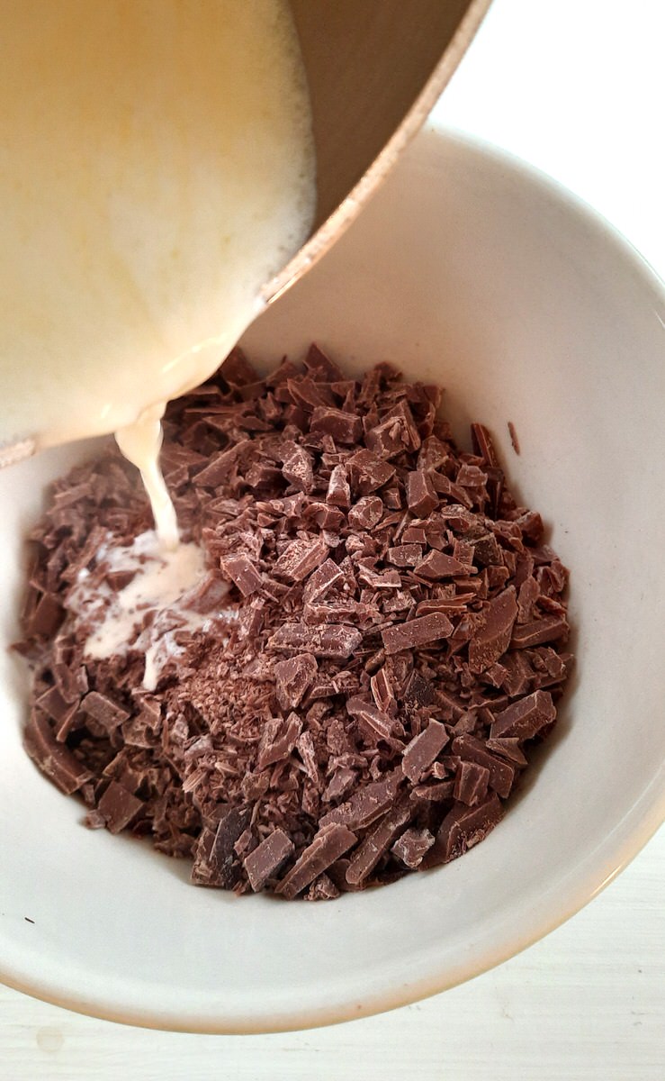 hot cream is poured slowly over finely chopped chocolate