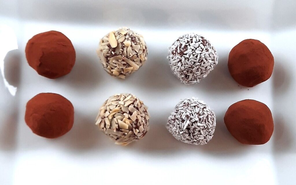 a white plate holds an arrangement of chocolate truffles