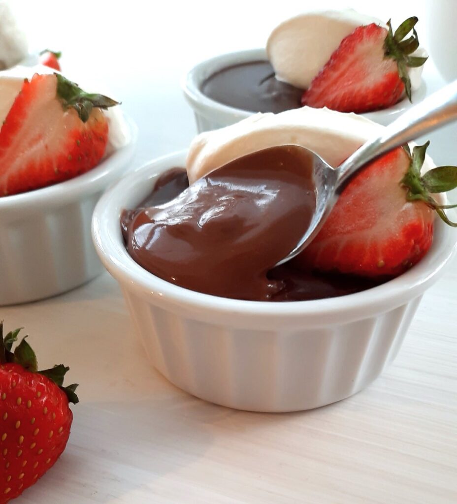 chocolate pudding flowing off a spoon into a bowl of rich pudding