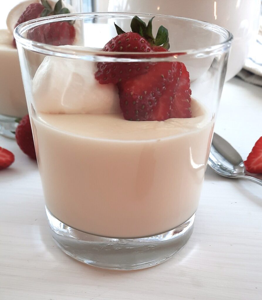 homemade vanilla pudding on a white counter in a small serving dish