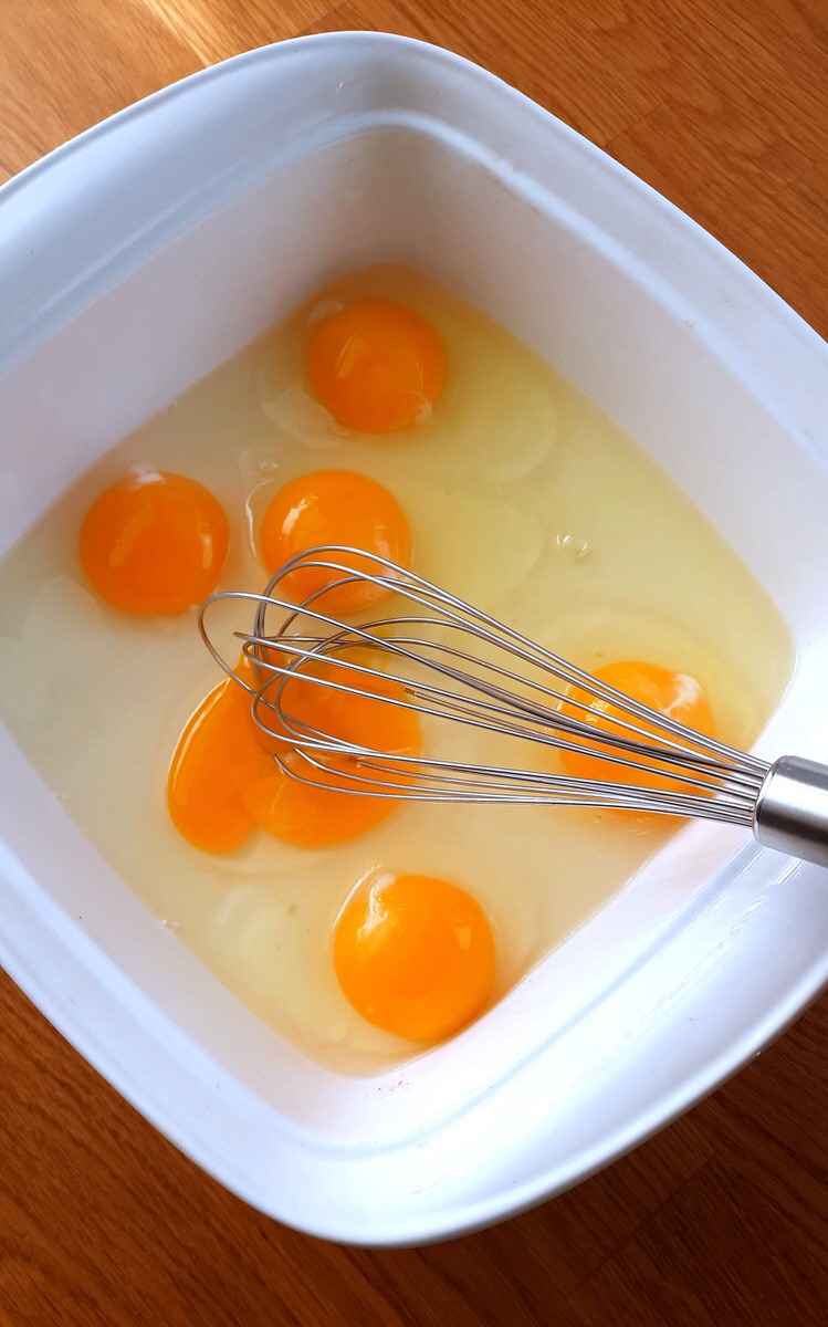 six eggs in a white baking dish