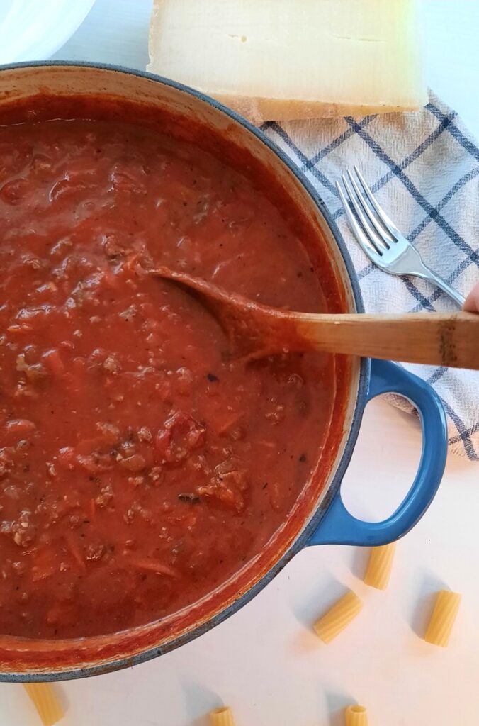 large pot of easy homemade pasta sauce on a counter with parmesan cheese nearby