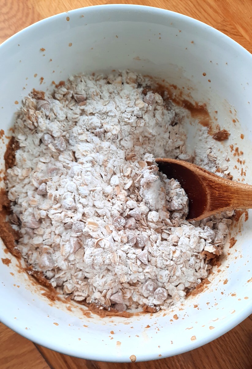 mixing dry cookie ingredients into wet ingredients