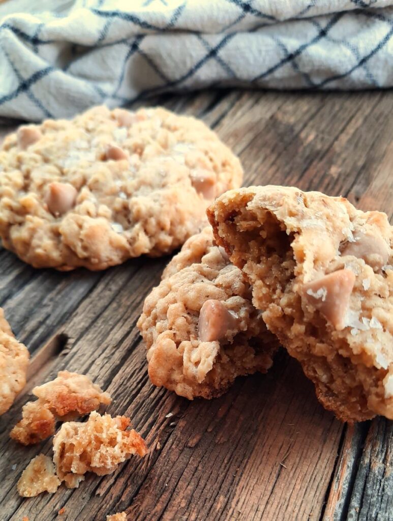 a broken caramel oatmeal cookie rests on a counter