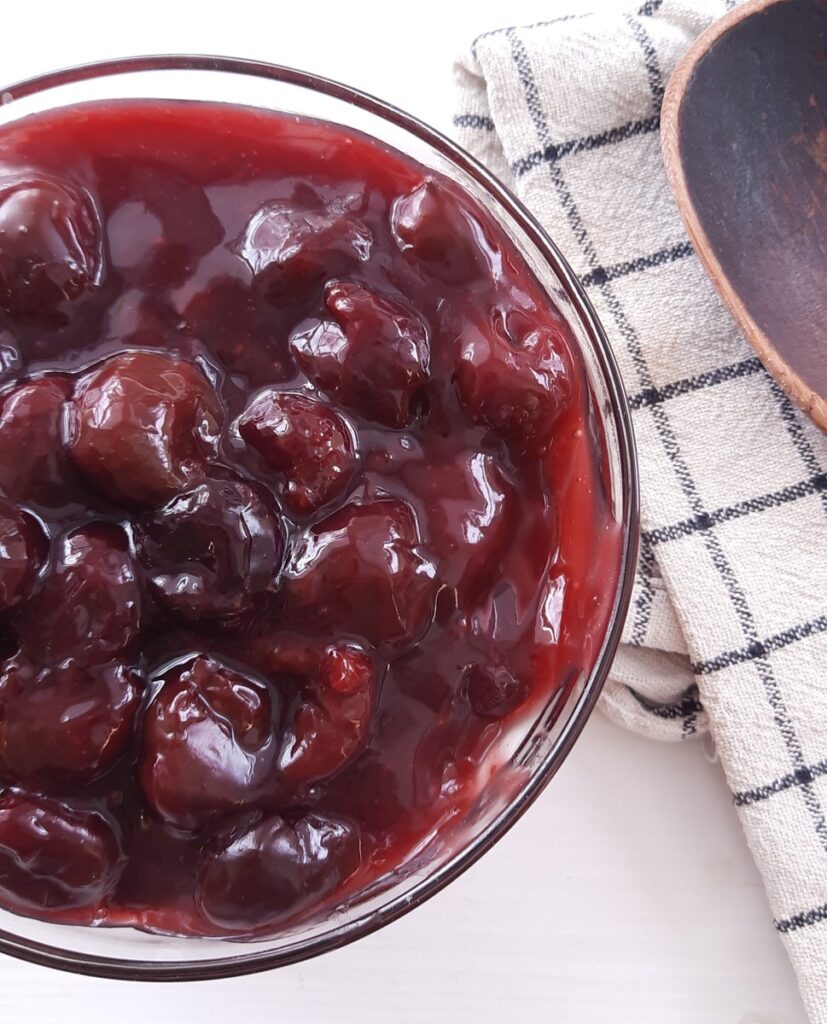 glass bowl full of homemade cherry pie filling on a white counter