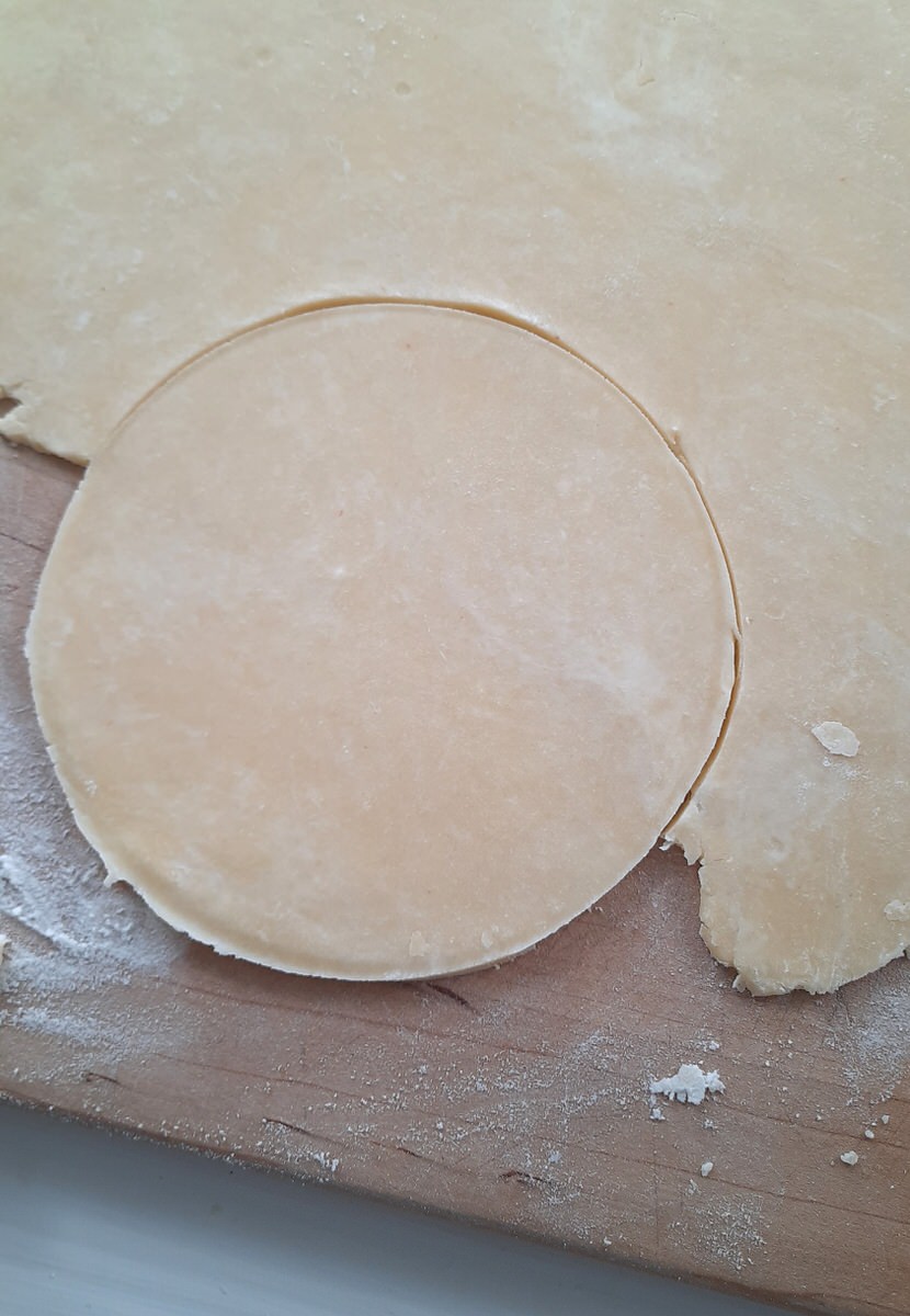 a circle of pie crust on a cutting board