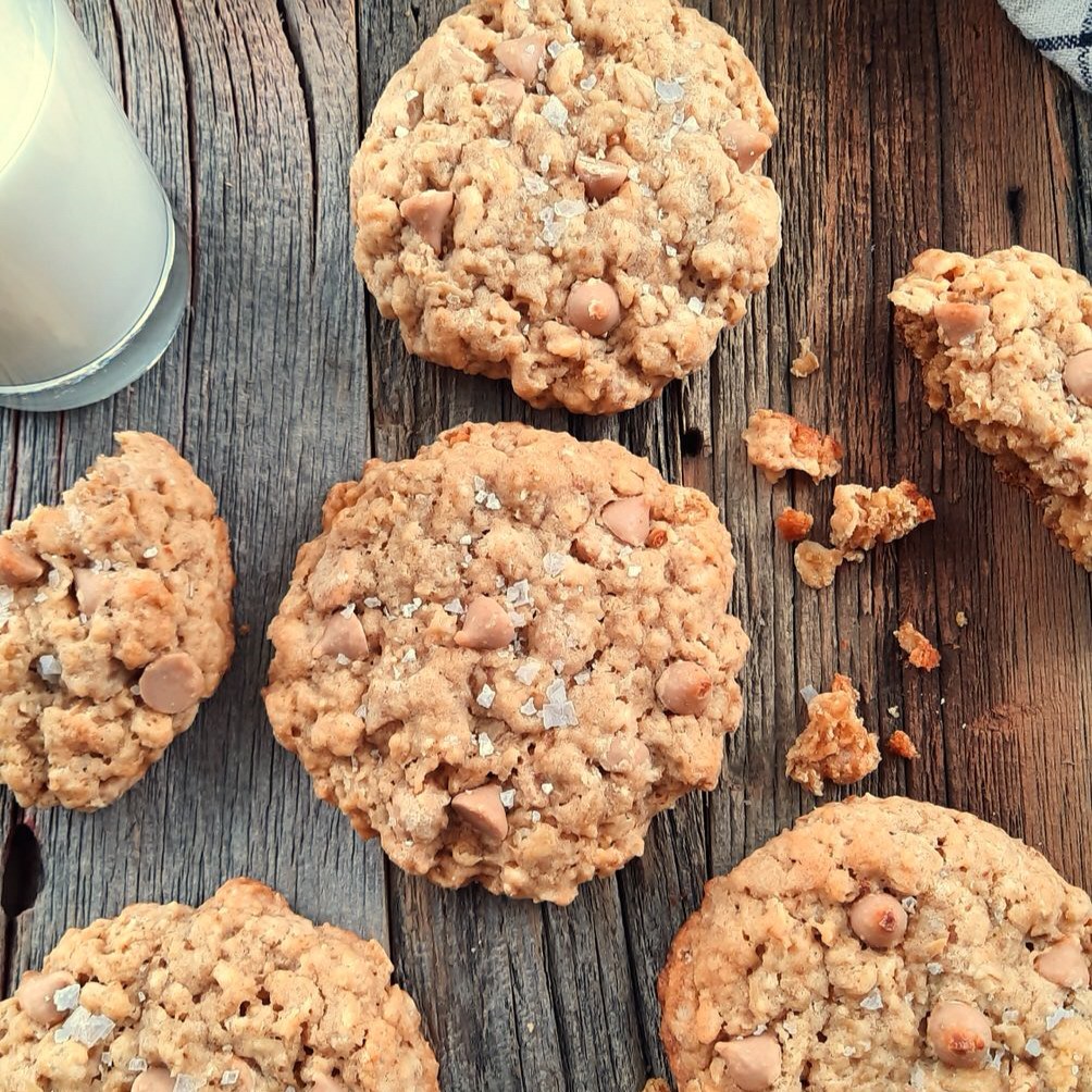 salted caramel oatmeal cookies surrounded by cookie crumbs on a wooden counter