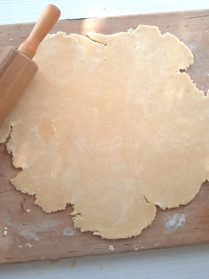 rolled pie dough on a cutting board