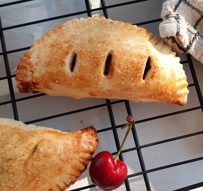a close up of a freshly baked cherry hand pie