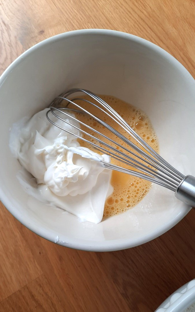 whisking sour cream into beaten egg