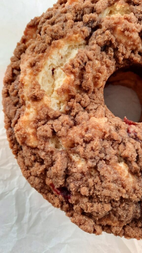 a close up of crumble topping on cranberry sour cream coffee cake