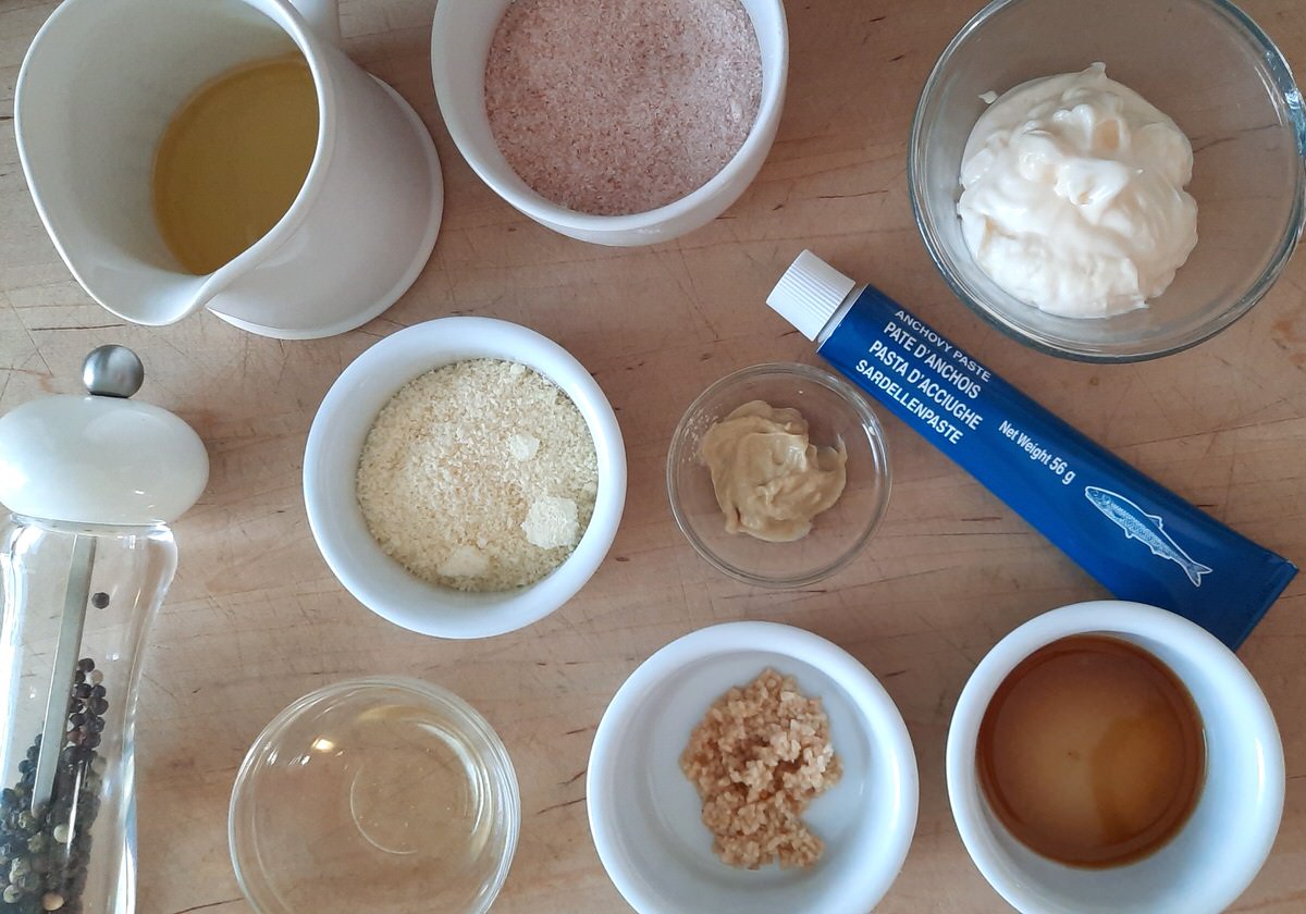 a top picture of all of the ingredients to make creamy caesar salad dressing