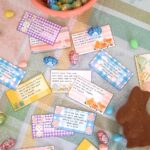 an array of easter egg hunt cards scattered on a colourful spring table cloth with a chocolate bunny and chocolate mini eggs