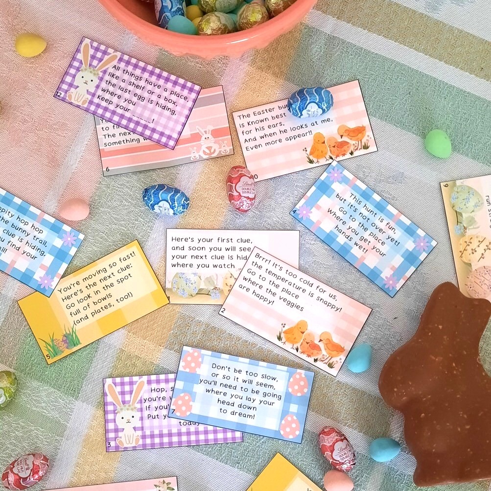 an array of easter egg hunt cards scattered on a colourful spring table cloth with a chocolate bunny and chocolate mini eggs