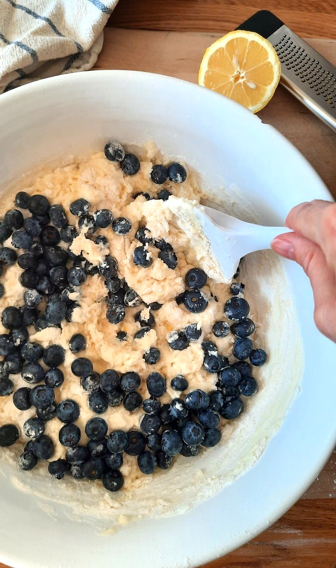 stirring blueberries into coffee cake batter