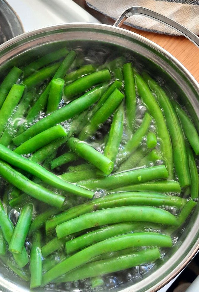 green beans simmering in a pot of water for a few minutes