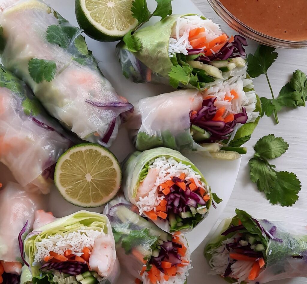 fresh spring rolls on a plate, some sliced in half, some whole
