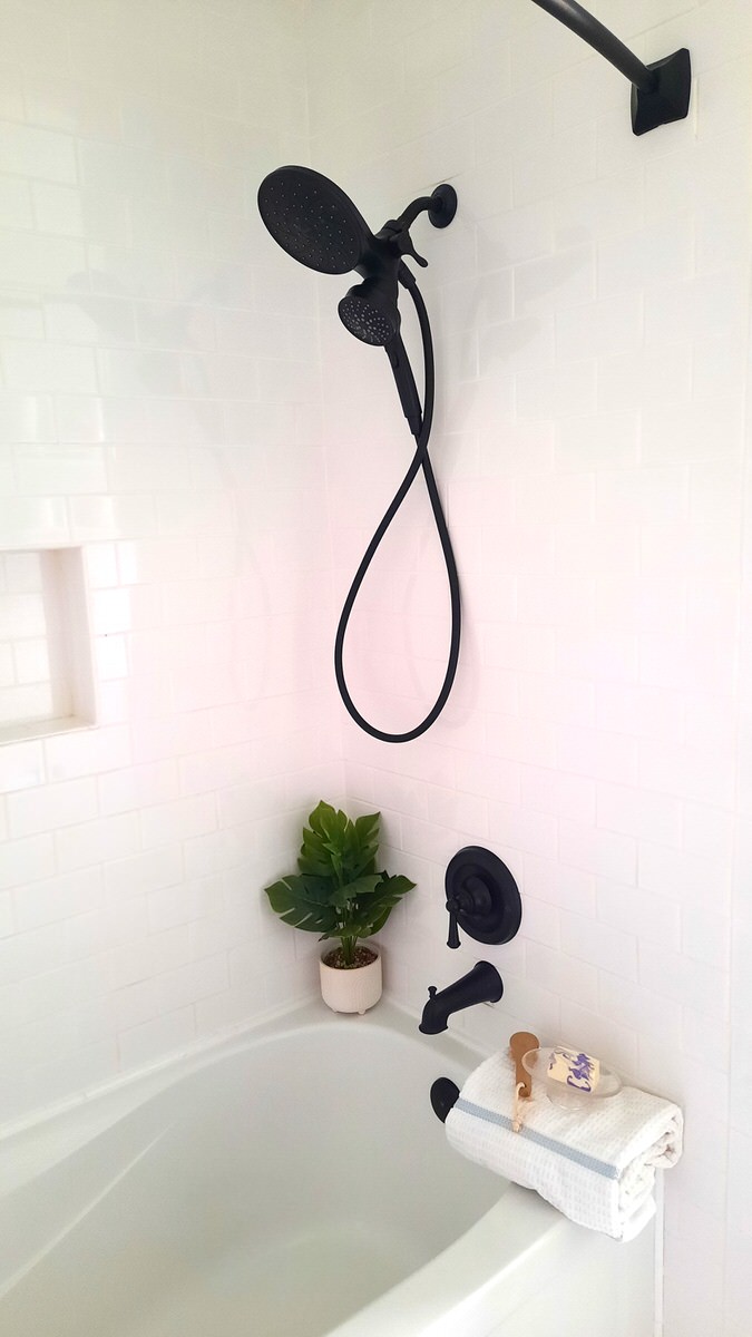 white bathtub with black fixures, a towel and a nice bar of soap show off a spa like bathtub