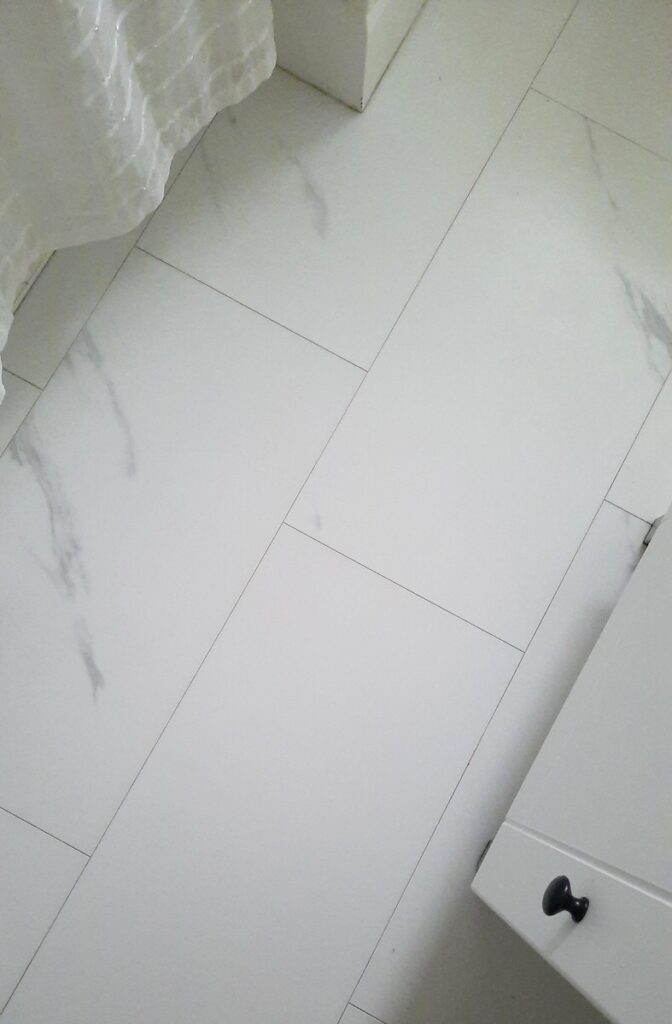 close up of white luxury vinyl tile on bathroom floor 