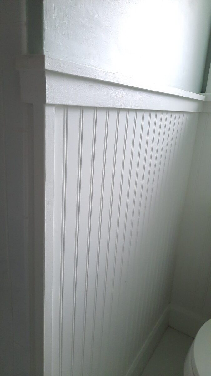 close up of beadboard painted white in small bathroom