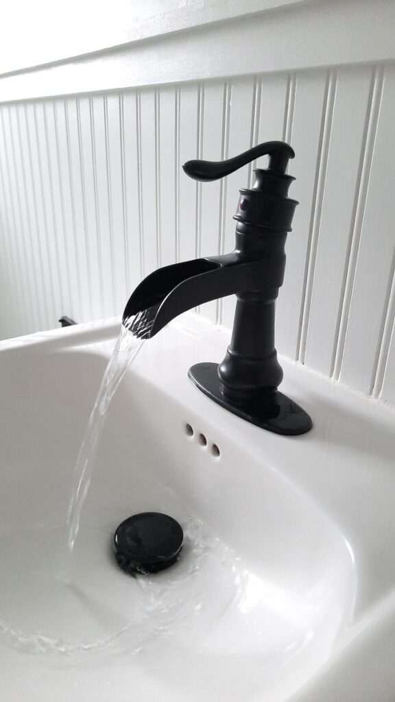 black waterfall faucet on a white sink