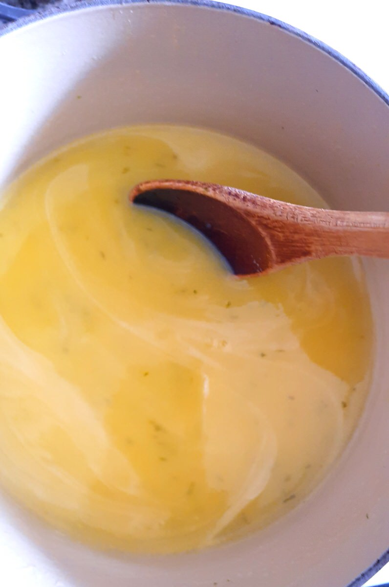 stirring lime curd with a wooden spoon while it heats up